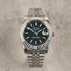 Silver Seiko watch with black dial on a gray textured background