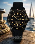 Black Seiko watch with yellow accents on a wooden surface with a blurred background