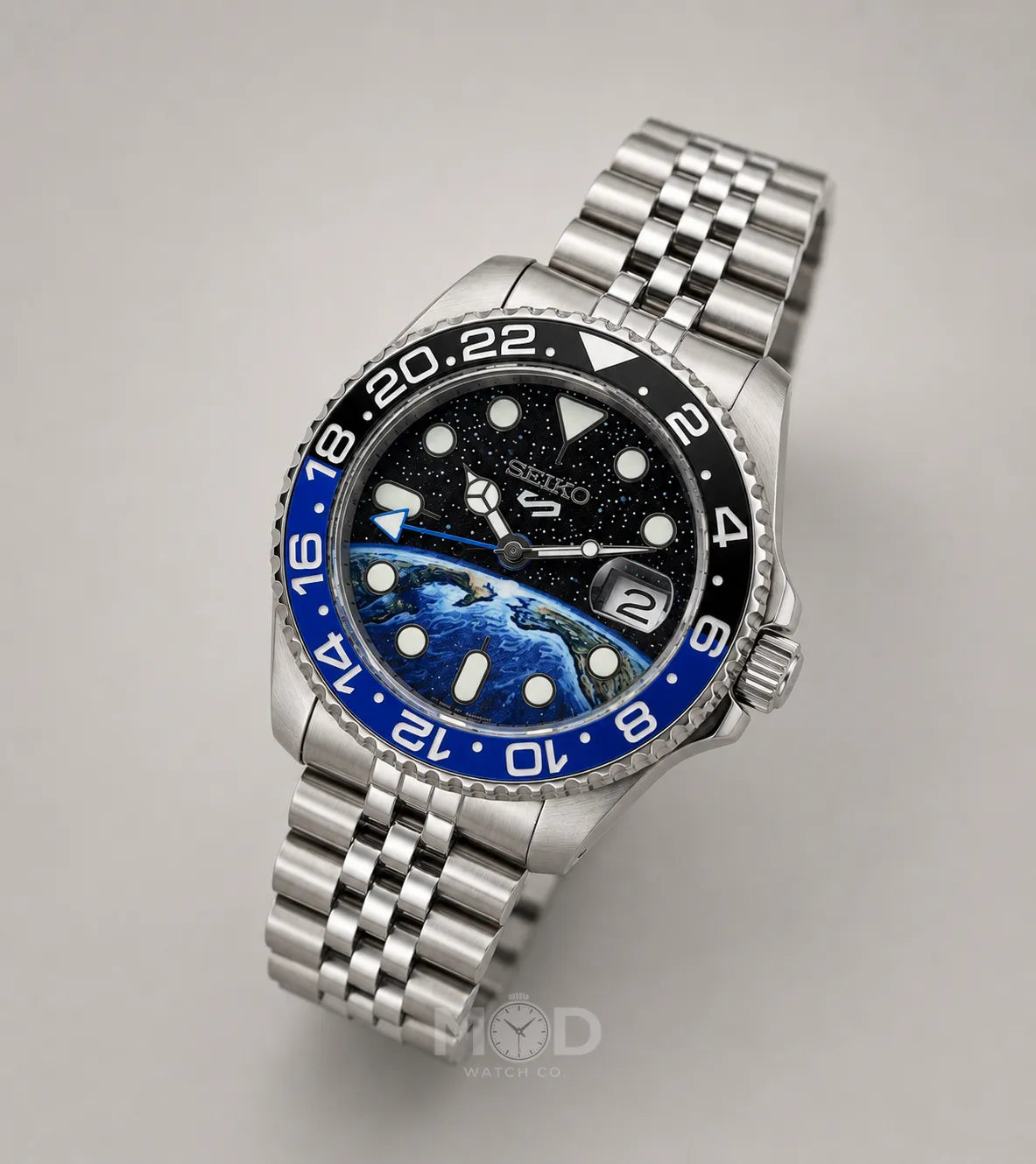 Silver watch with a blue and black face on a gray background