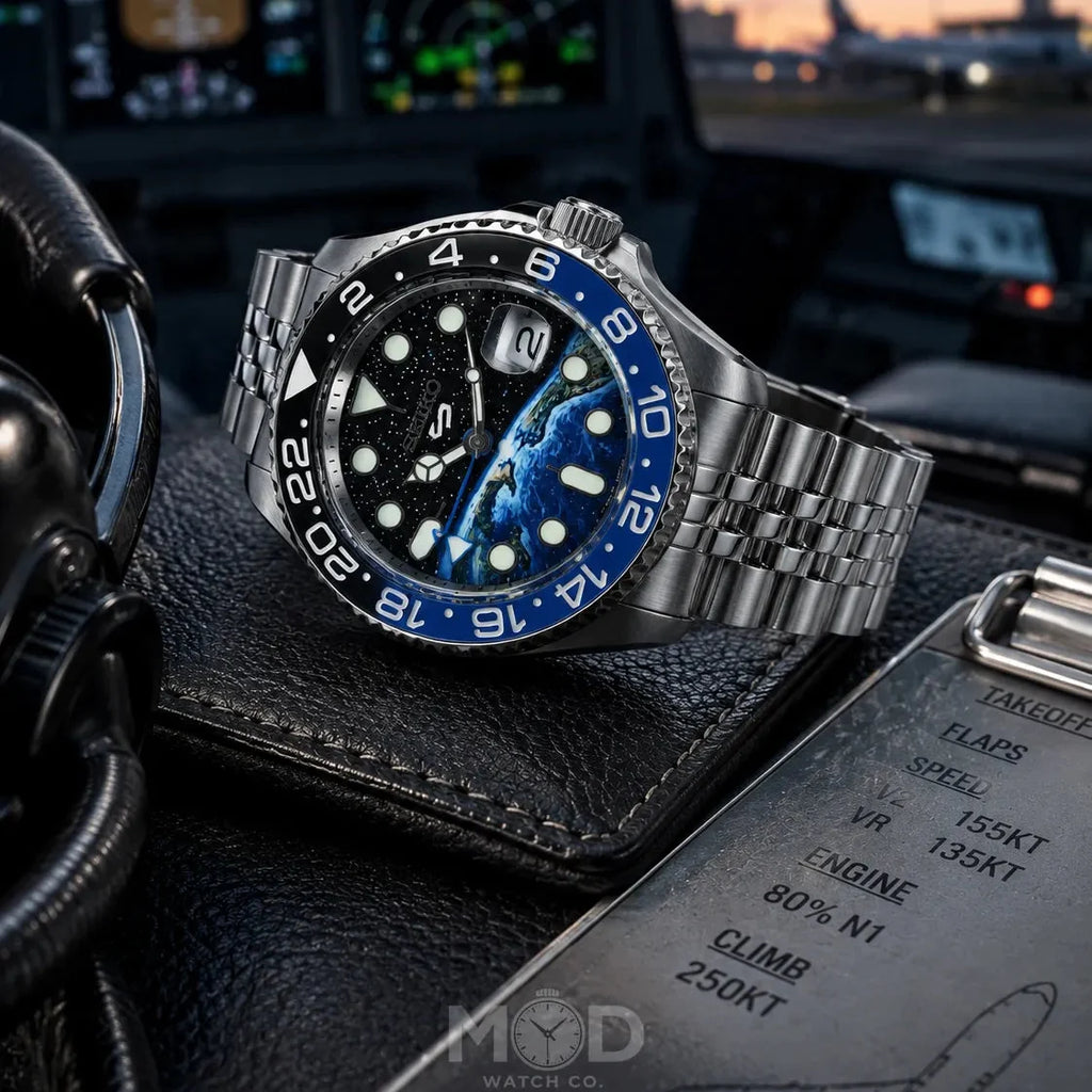 Watch with blue bezel on a leather surface with aviation instruments in the background