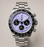 A Seiko stainless steel chronograph watch with a light purple dial, black bezel, and matching metal link bracelet, shown against a neutral beige background.